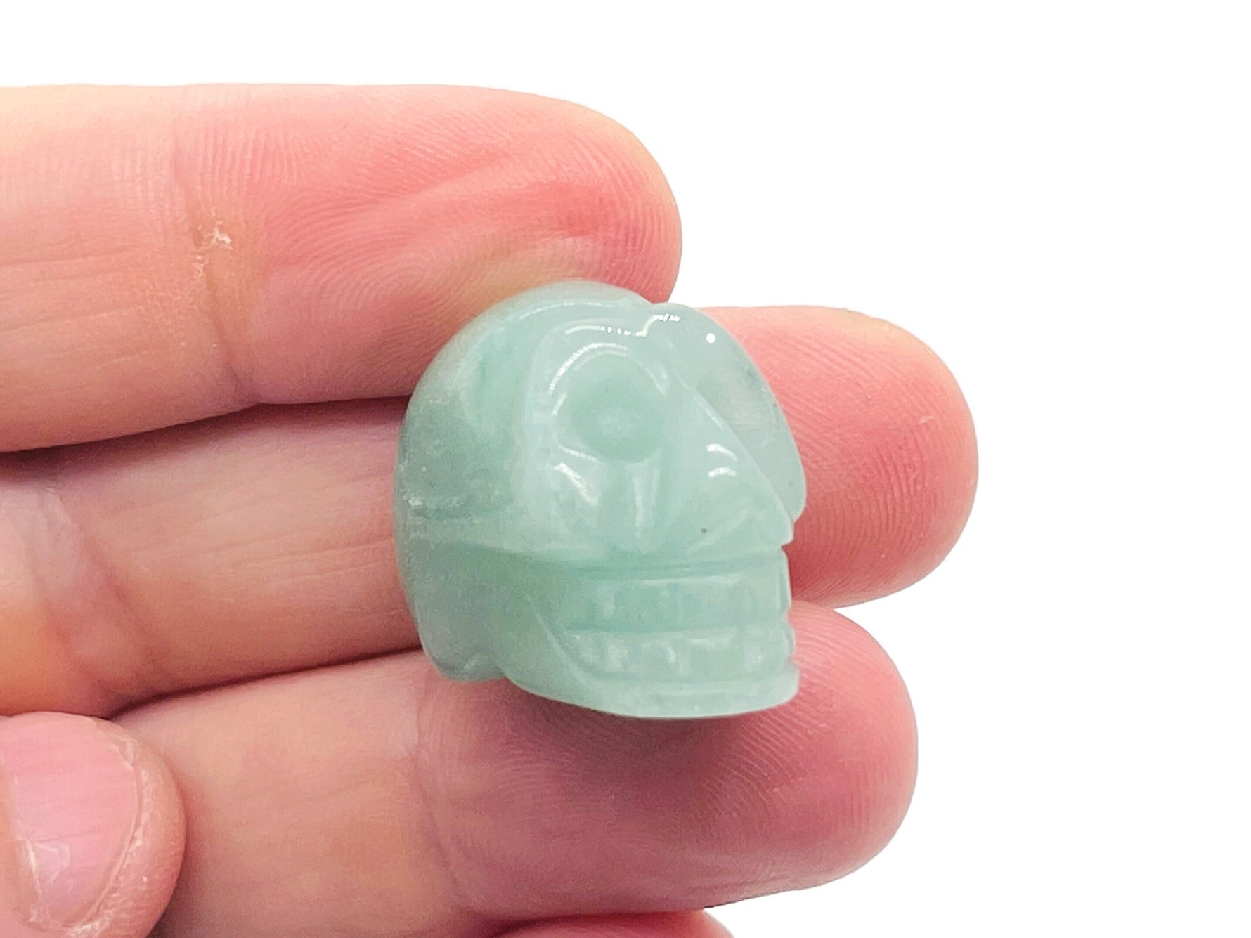 A 25mm carved aventurine skull gemstone by GemstoneGO, showcasing detailed craftsmanship and vibrant green color.