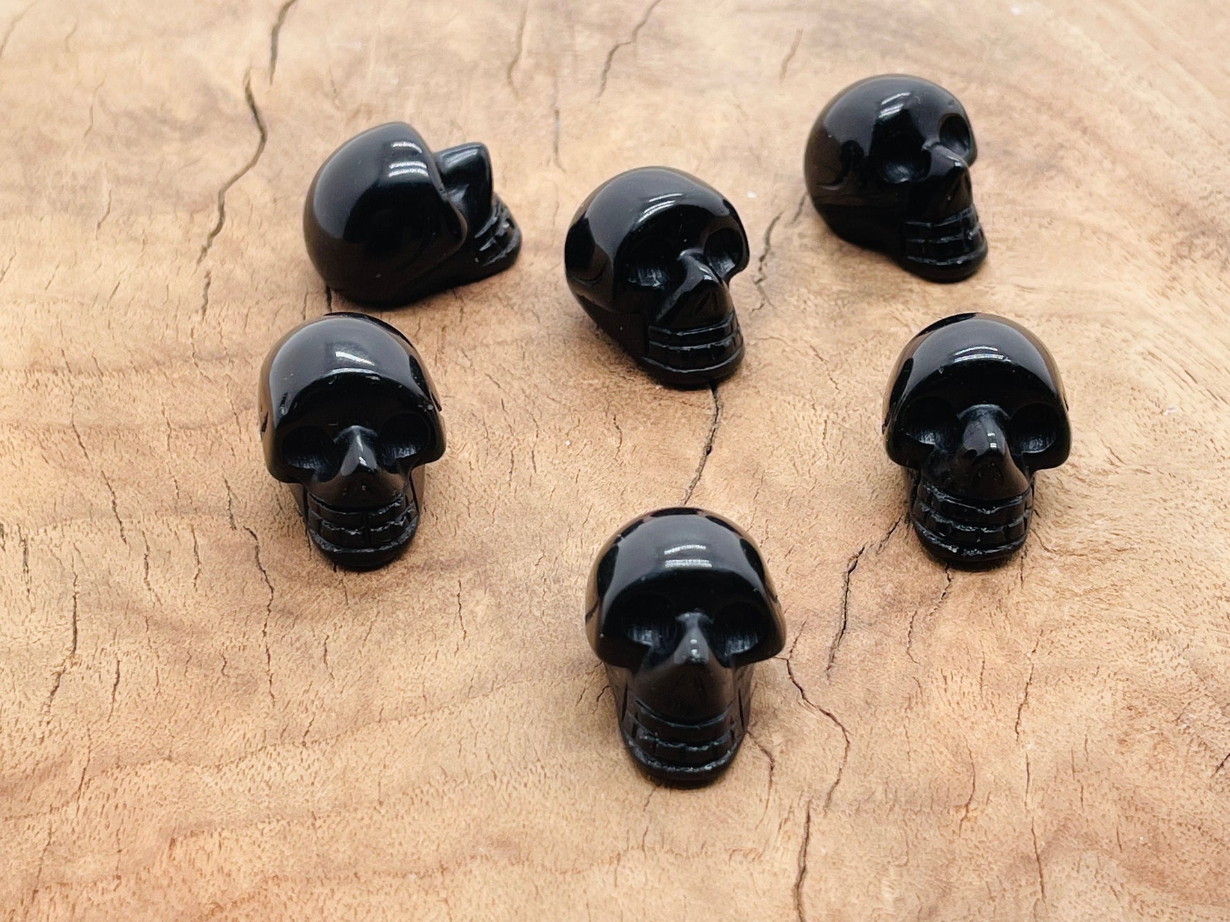 Carved 25mm obsidian skull gemstone from GemstoneGO showing detailed black stone carving on a white background.