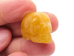 Orange aventurine skull carved gemstone, 25mm, with detailed facial features and polished surface, from GemstoneGO.