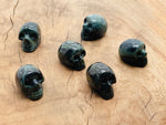 Kambaba Jasper skull carved gemstone, 25mm, with detailed natural green and black swirling patterns, by GemstoneGO.