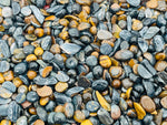 Blue tiger eye crystal chips, semi-tumbled 5-7mm gemstones from GemstoneGO, arranged in a pile for bulk use.