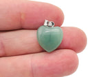 A close-up of a GemstoneGO aventurine heart pendant, a mini crystal jewelry piece with a polished green gemstone heart.