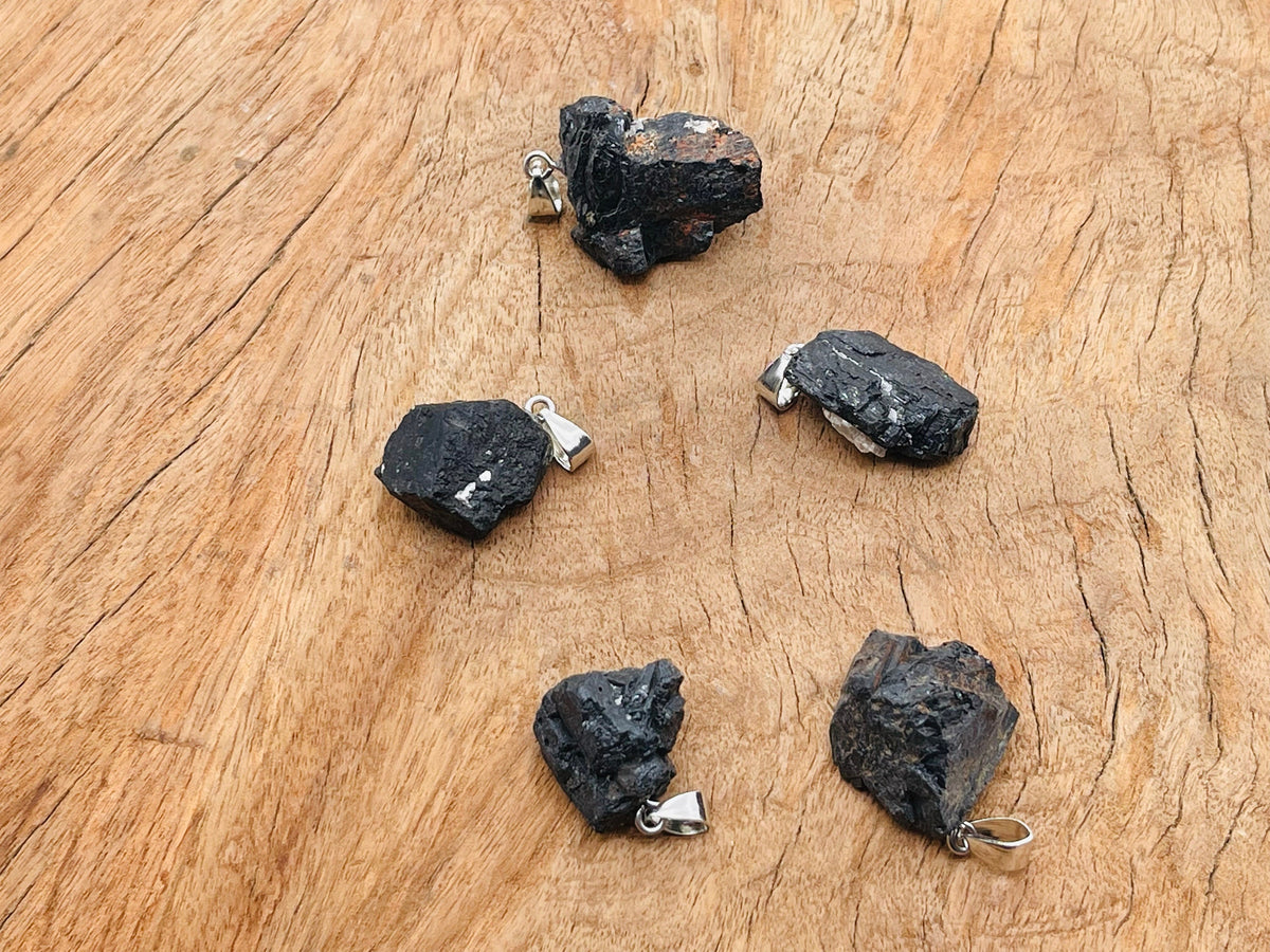 Black Tourmaline crystal pendant from GemstoneGO featuring a polished black stone on a silver chain.