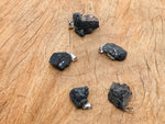 Black Tourmaline crystal pendant from GemstoneGO featuring a polished black stone on a silver chain.