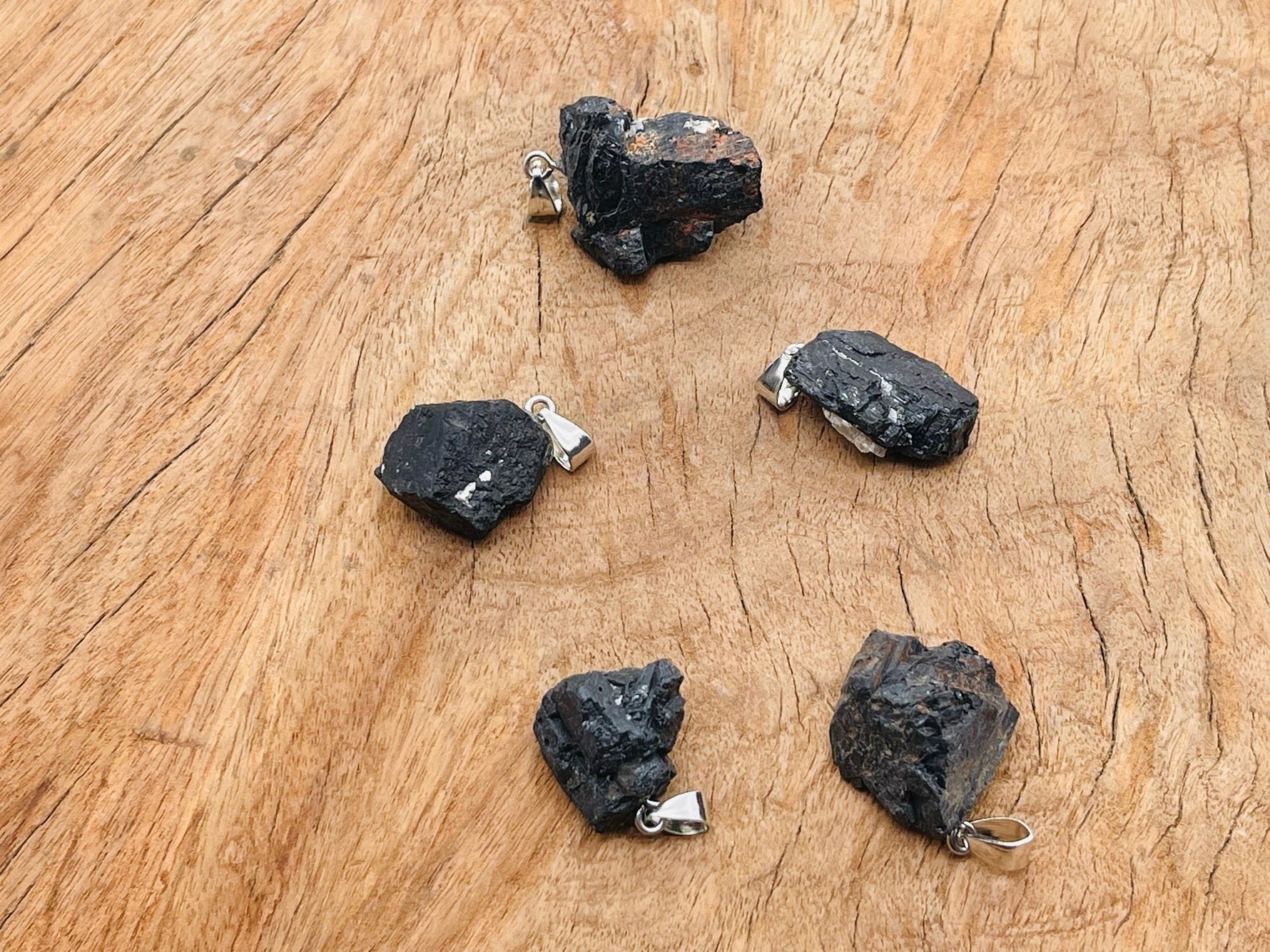 Black Tourmaline crystal pendant from GemstoneGO featuring a polished black stone on a silver chain.