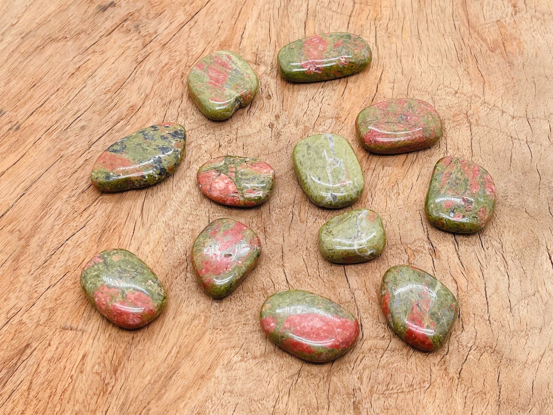 Unakite flat gemstone slab from GemstoneGO showing green and pink mineral layers on a neutral background.
