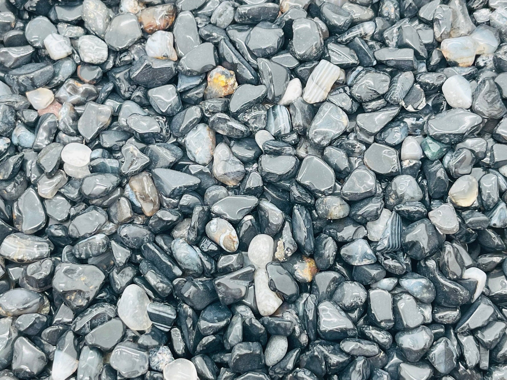 Semi-tumbled black agate crystal chips, 5-8mm gemstone stones from GemstoneGO, displayed in a bulk pack.
