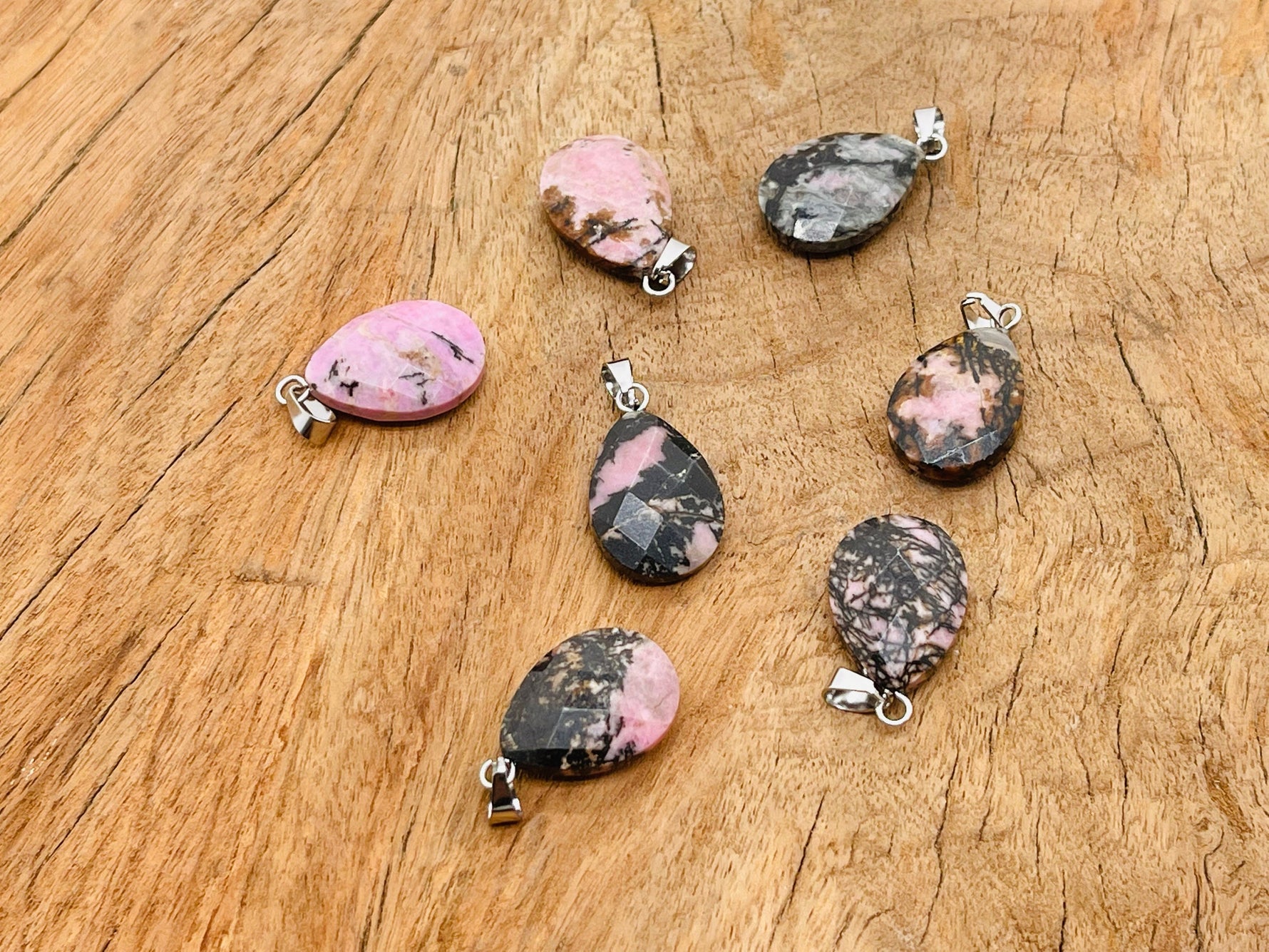20mm Rhodonite crystal pendant from GemstoneGO, ideal for jewelry making, showcasing a polished pink and black gemstone.