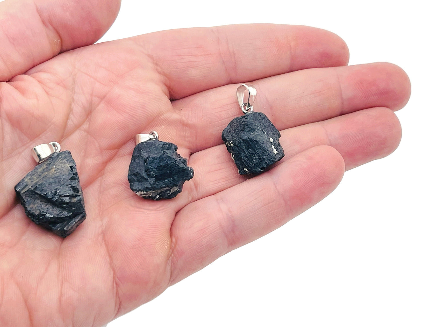 Black Tourmaline crystal pendant from GemstoneGO featuring a polished black stone pendant on a silver chain.