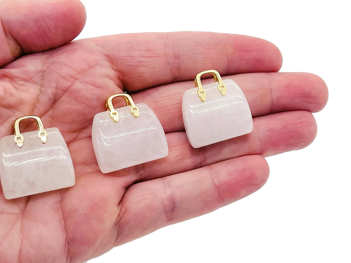 Clear Quartz crystal handbag pendant with detailed carving, gemstone jewelry accessory, gemstoneGO brand, elegant and polished appearance.