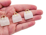 Clear Quartz crystal handbag pendant with detailed carving, gemstone jewelry accessory, gemstoneGO brand, elegant and polished appearance.