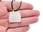Clear quartz crystal purse carving gemstone with a handbag pendant design, showcasing a polished, transparent gemstone.