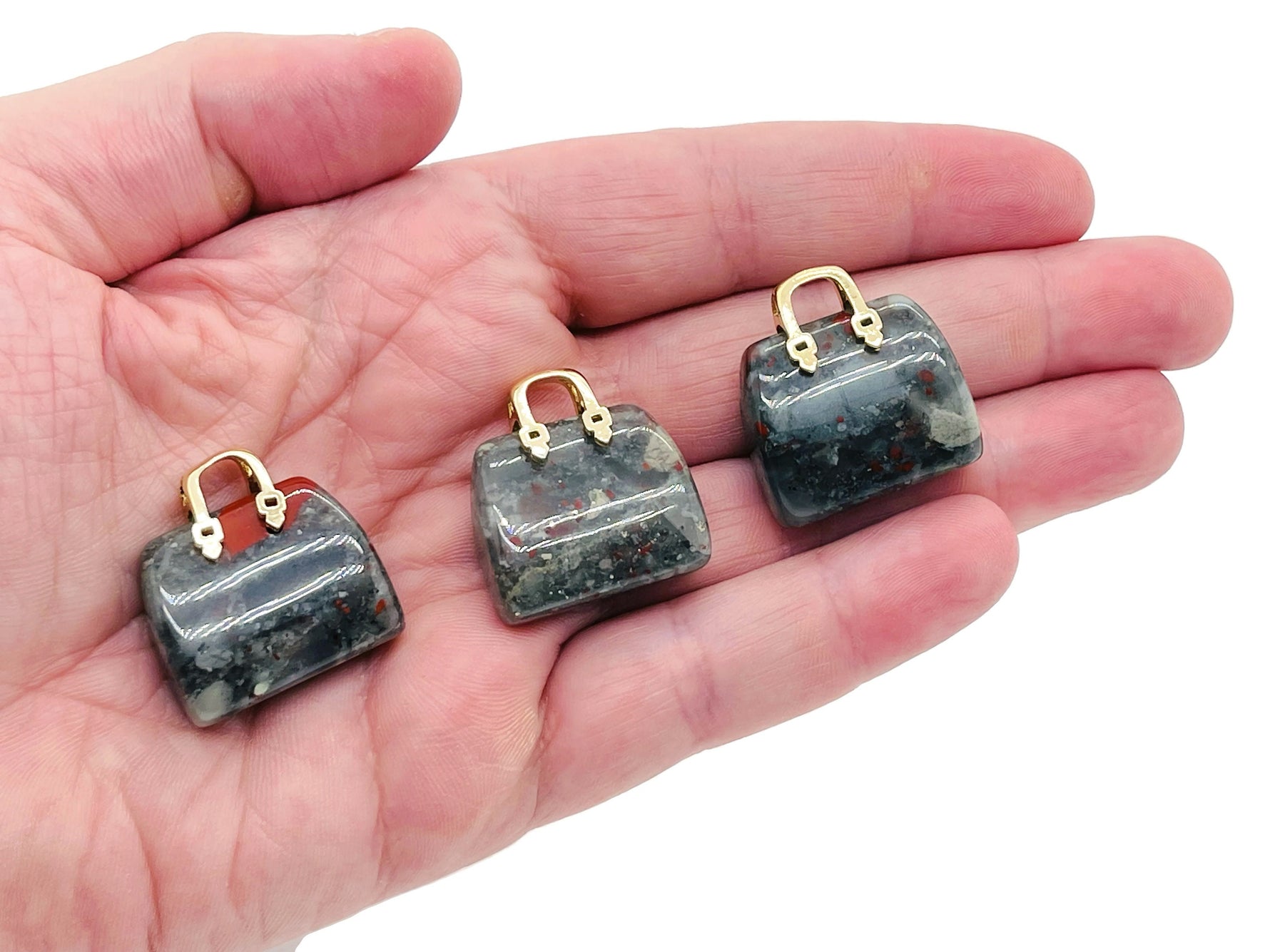 African Bloodstone crystal purse carving gemstone pendant featuring a detailed handbag design, ideal for jewelry and collectibles.