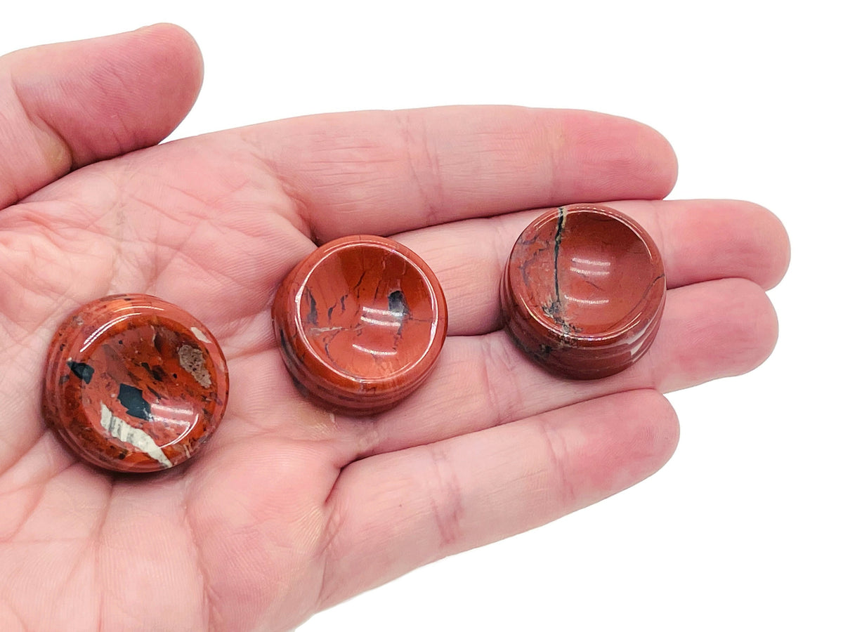 Red Jasper crystal sphere resting on a carved gemstone stand, ideal for home decor and spiritual healing.