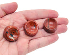 Red Jasper crystal sphere resting on a carved gemstone stand, ideal for home decor and spiritual healing.