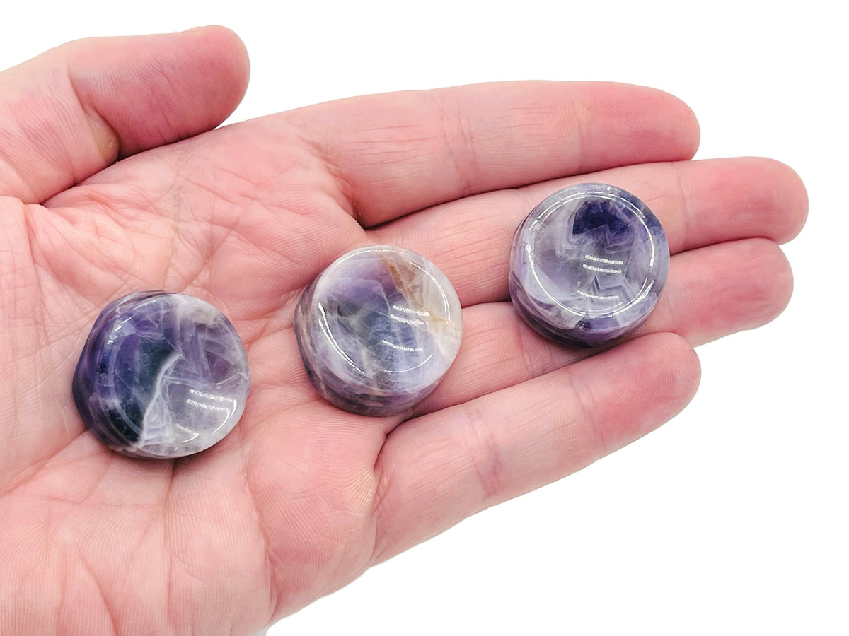 Amethyst crystal sphere on carved gemstone stand, decorative home decor piece showcasing purple amethyst gemstone.
