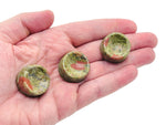 Unakite crystal sphere on carved gemstone stand, showcasing vibrant green and pink hues for home decor display.