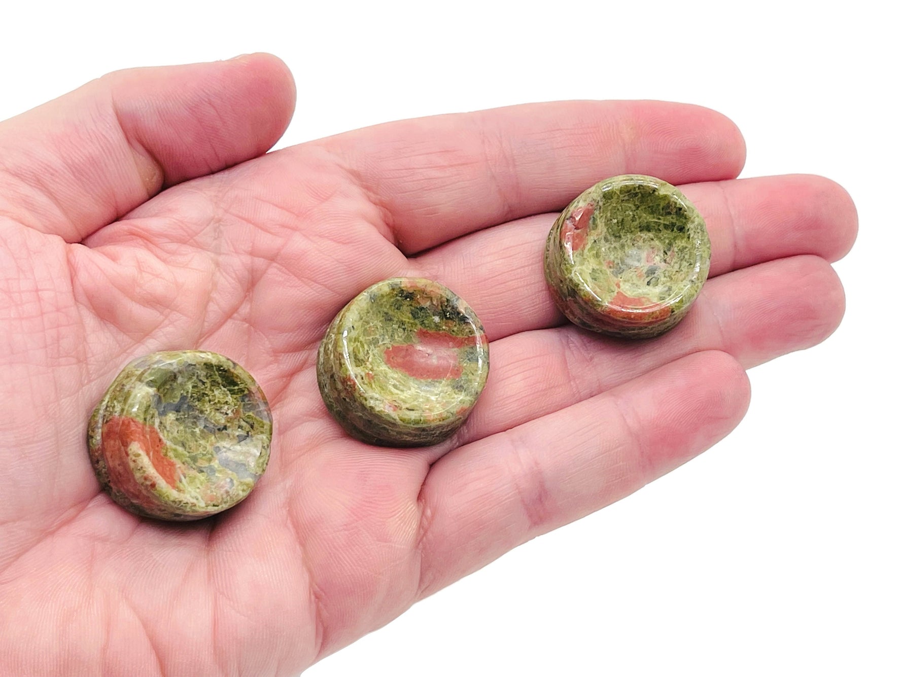 Unakite crystal sphere on carved gemstone stand, showcasing vibrant green and pink hues for home decor display.