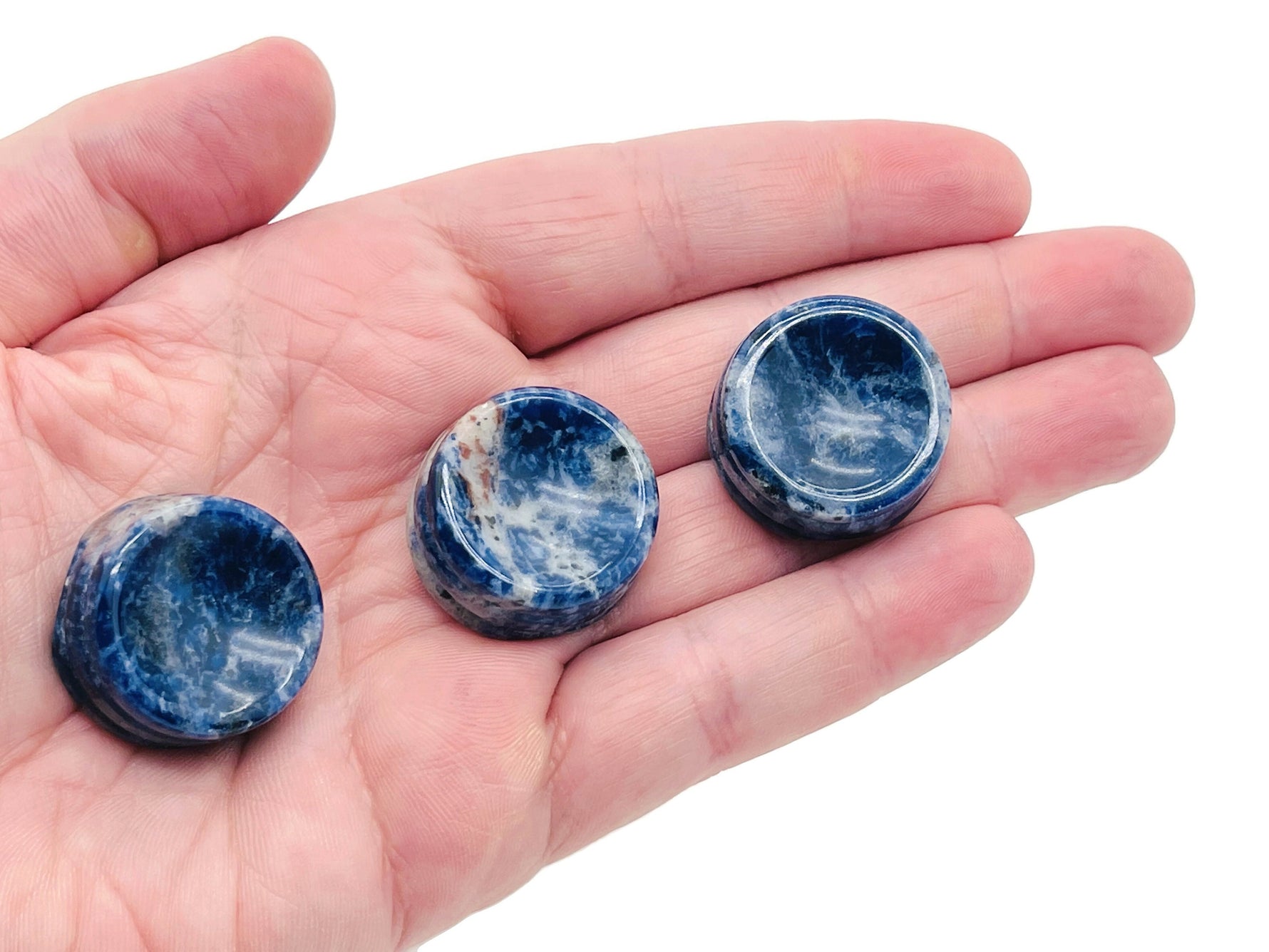 Sodalite crystal sphere on a carved gemstone stand, showcasing vibrant blue and white patterns, ideal for home decor.