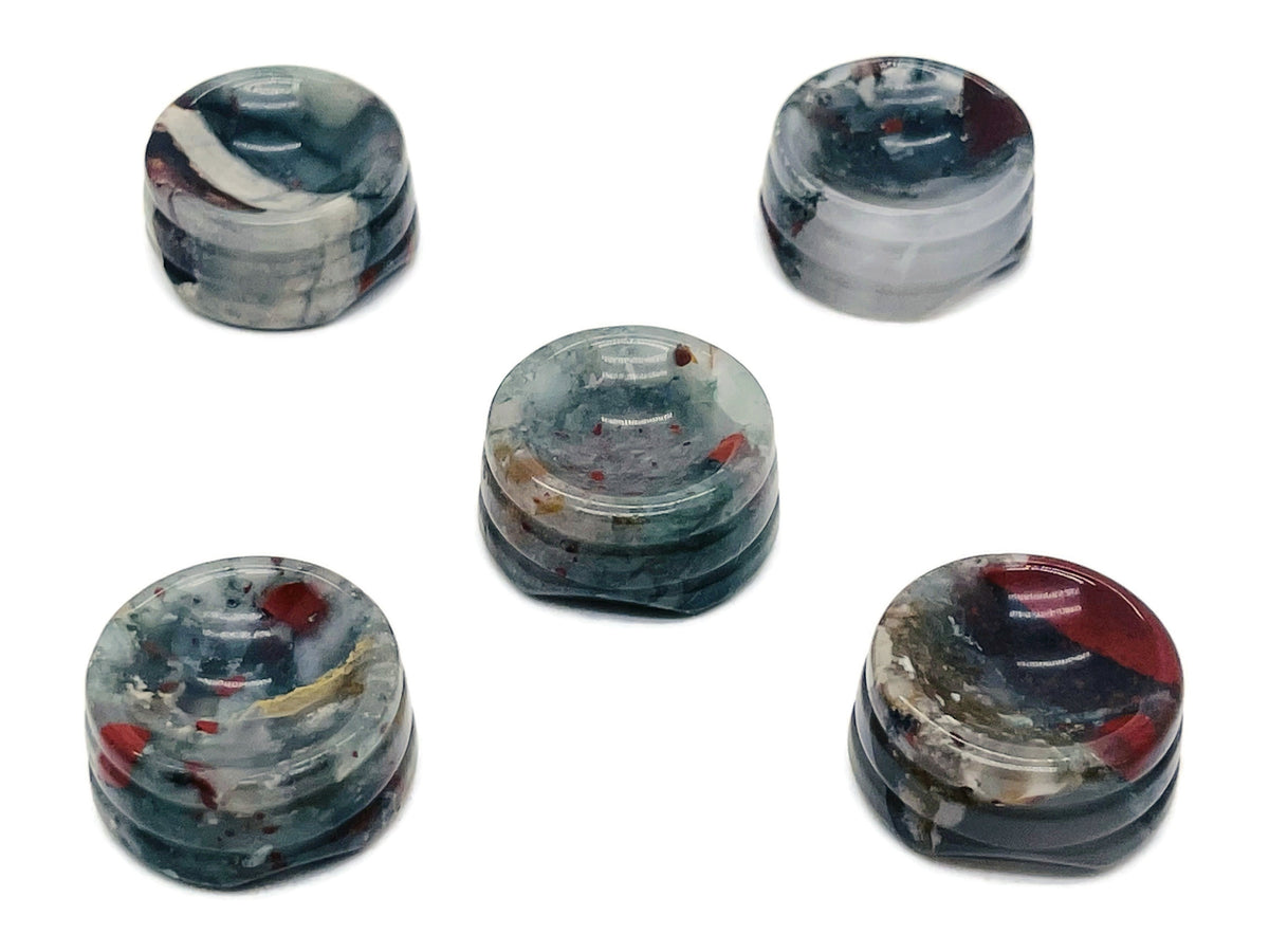 African Bloodstone crystal sphere on a carved gemstone stand, used as a decorative home accent with rich green and red hues.