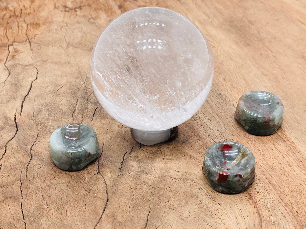 African Bloodstone crystal sphere on a carved gemstone stand, perfect for home decor and display.