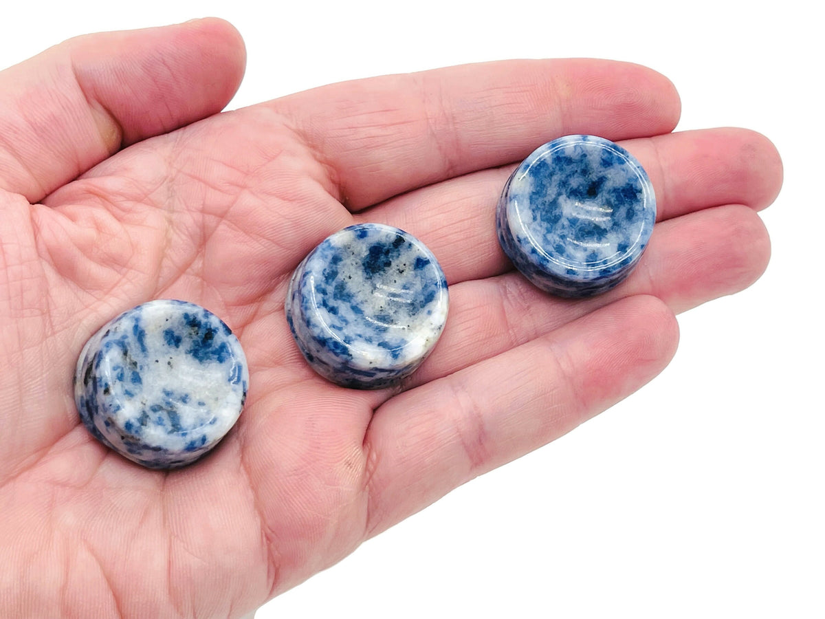 Blue Spot Jasper crystal sphere on a carved gemstone stand, used as elegant home decor piece.