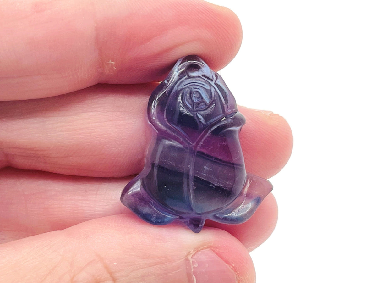 Fluorite rose flower carving gemstone from GemstoneGO, showing a detailed, colorful floral design in vibrant purple and green hues.