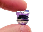 Fluorite crystal carving gemstone from GemstoneGO, vibrant purple and green hues with intricate natural patterns.