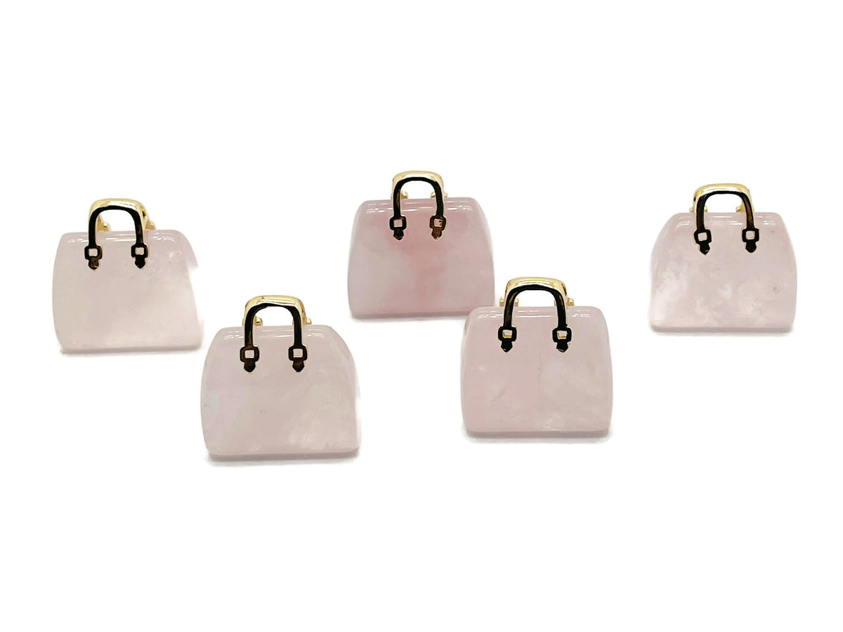 Rose quartz crystal gemstone carved as a handbag pendant, featuring detailed carvings and a polished finish.