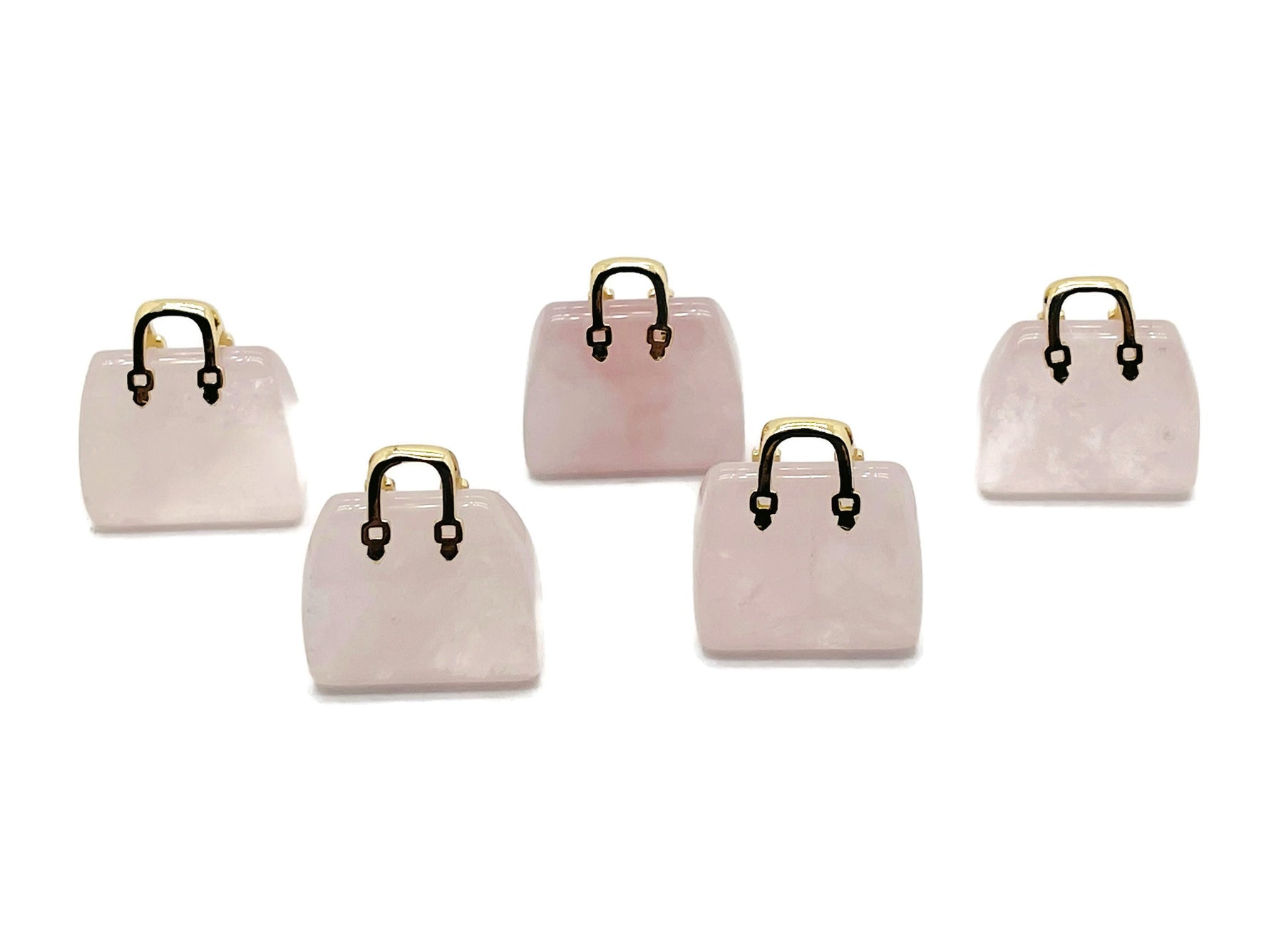 Rose quartz crystal gemstone carved as a handbag pendant, featuring detailed carvings and a polished finish.
