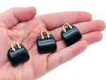 Obsidian crystal handbag pendant with detailed carving, featuring a polished gemstone design for jewelry or decorative use.