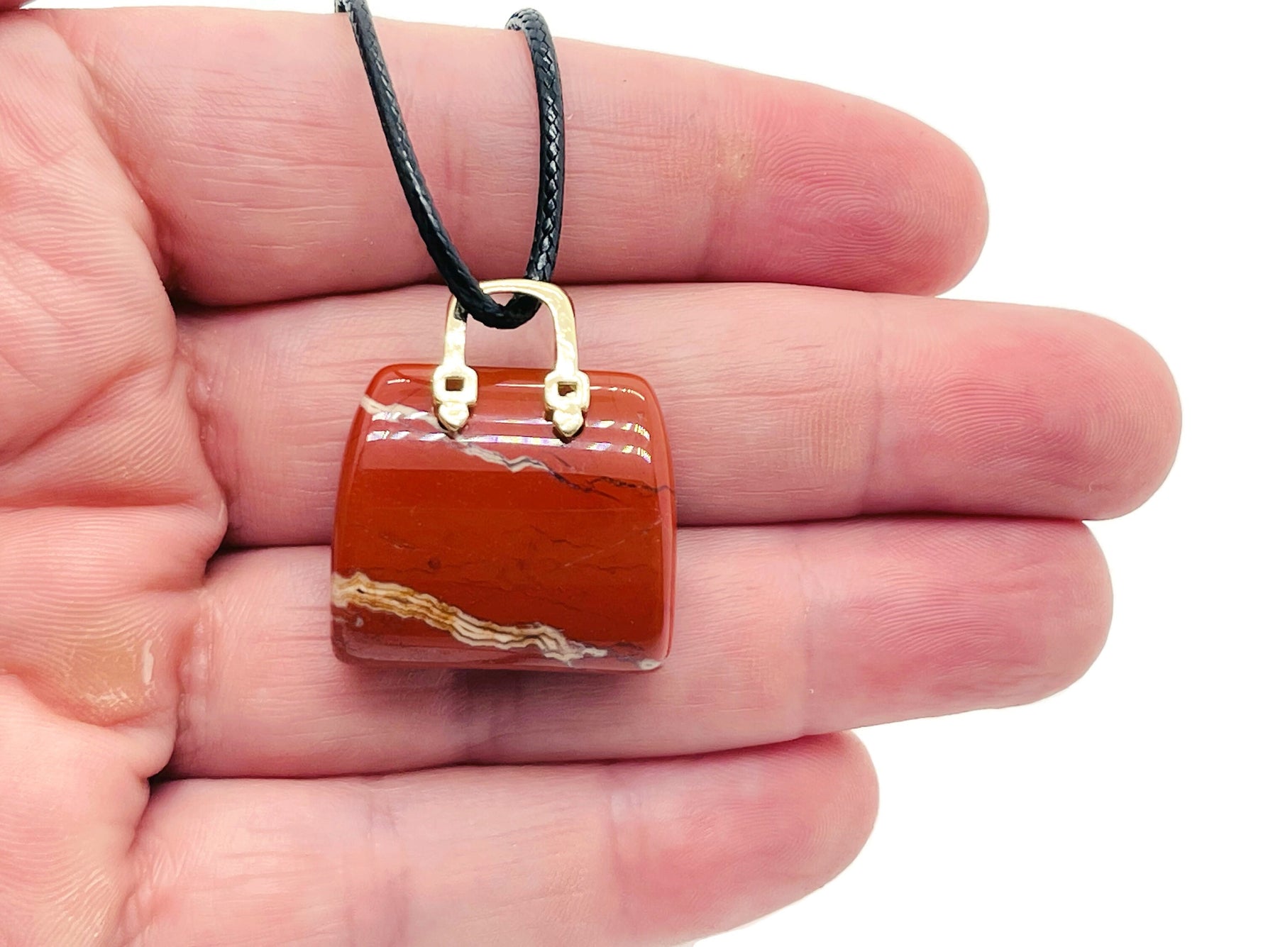 Red Jasper crystal purse carving gemstone pendant with detailed handbag design, showcasing vibrant red color and intricate craftsmanship.
