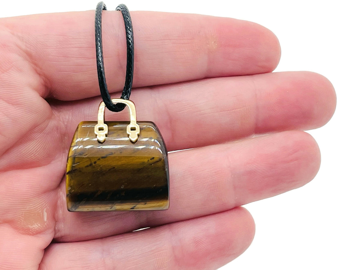 Tiger Eye crystal carving of a purse gemstone, handcrafted handbag pendant with detailed gemstone craftsmanship.