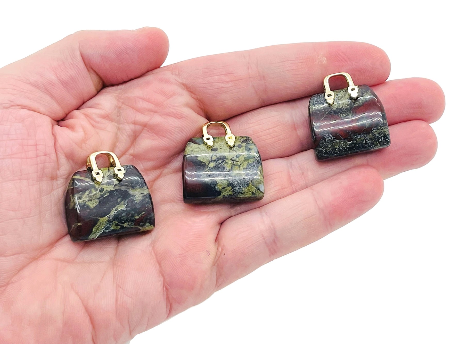 Dragon Blood Jasper gemstone pendant featuring a carved purse design, showcasing vibrant red and brown hues with intricate detailing.