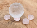 Rose quartz crystal sphere on carved gemstone stand, used as elegant home decor piece by GemstoneGO.
