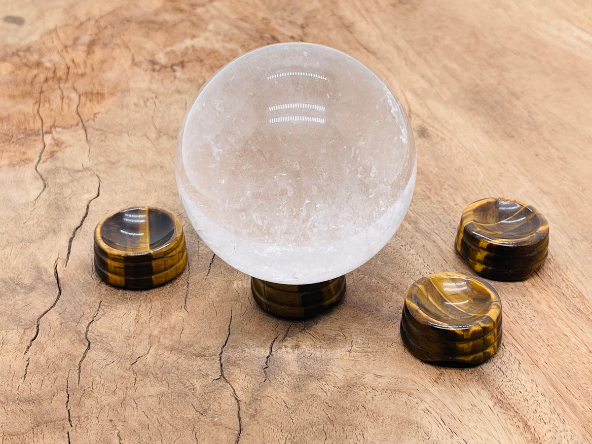 Tiger Eye crystal sphere on a carved gemstone stand, ideal for home decor with warm, golden-brown natural stone appearance.