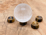 Tiger Eye crystal sphere on a carved gemstone stand, ideal for home decor with warm, golden-brown natural stone appearance.