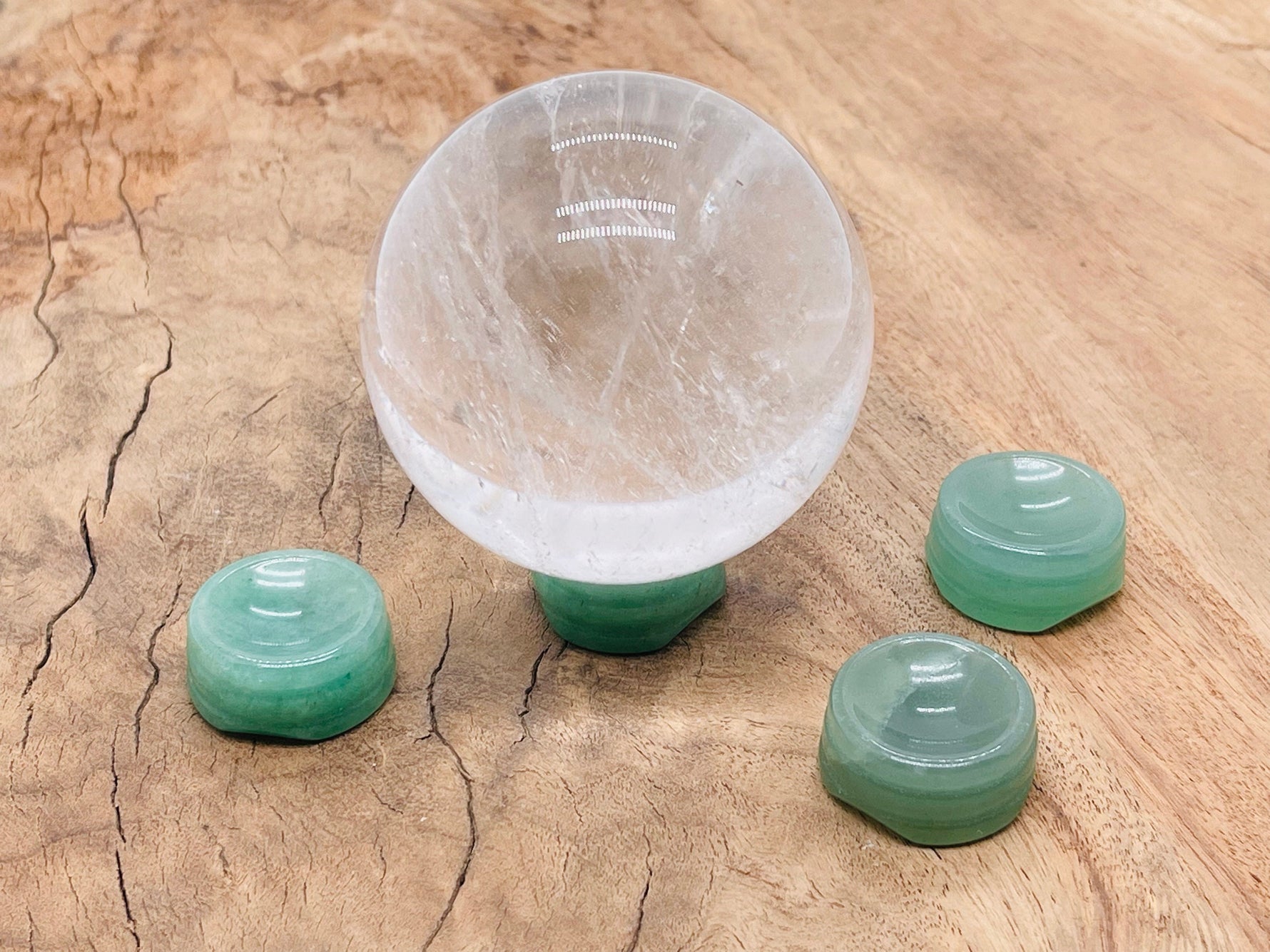 Aventurine crystal sphere on a carved gemstone stand, showcasing vibrant green hues, ideal for home decor display.