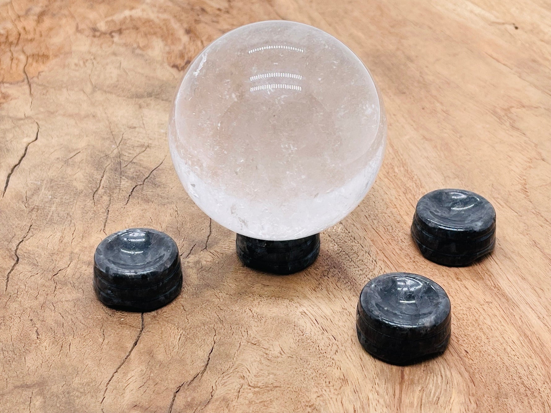 Larvikite crystal sphere on carved gemstone stand, used as elegant home decor piece by GemstoneGO.
