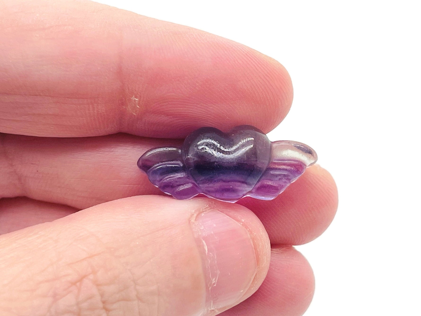 Fluorite wing heart gemstone carving from GemstoneGO, showing vibrant green and purple hues with detailed wing and heart design.