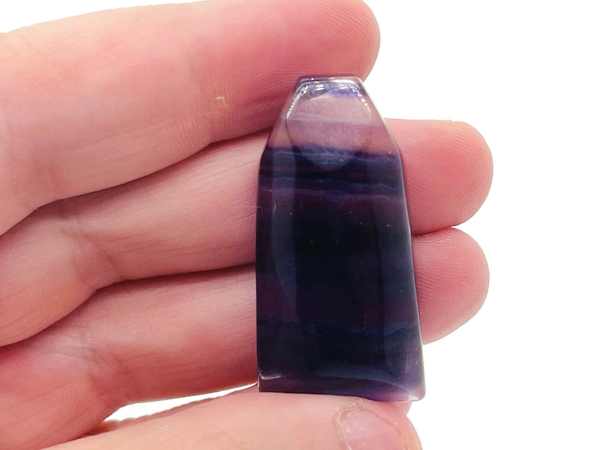 Fluorite flat tower gemstone carving by GemstoneGO showing vibrant purple and green hues with smooth polished surfaces.