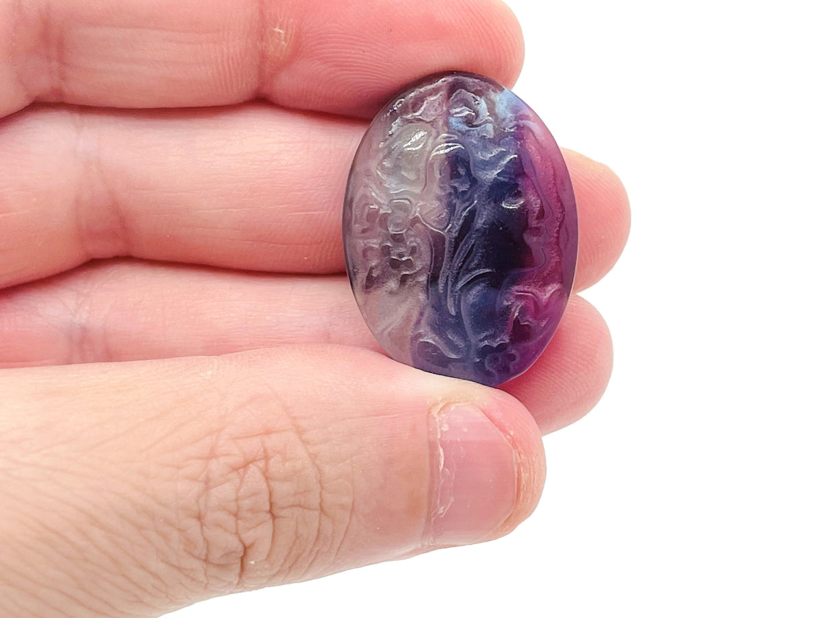 Fluorite lady portrait gemstone carving by GemstoneGO showcasing detailed craftsmanship and vibrant purple-green hues.