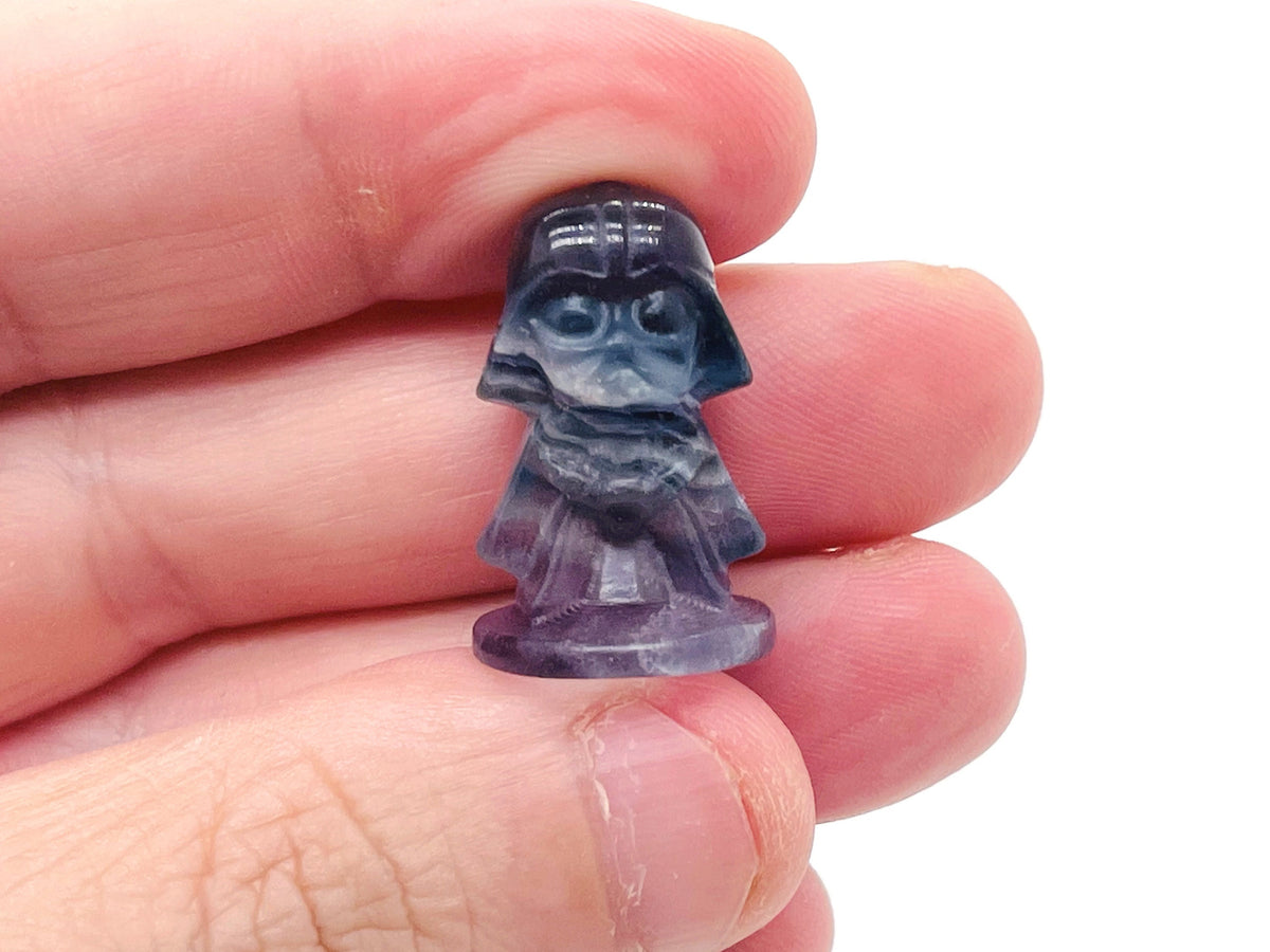 Fluorite Darth Vader carving gemstone from GemstoneGO, detailed dark purple and green mineral sculpture of Star Wars character.