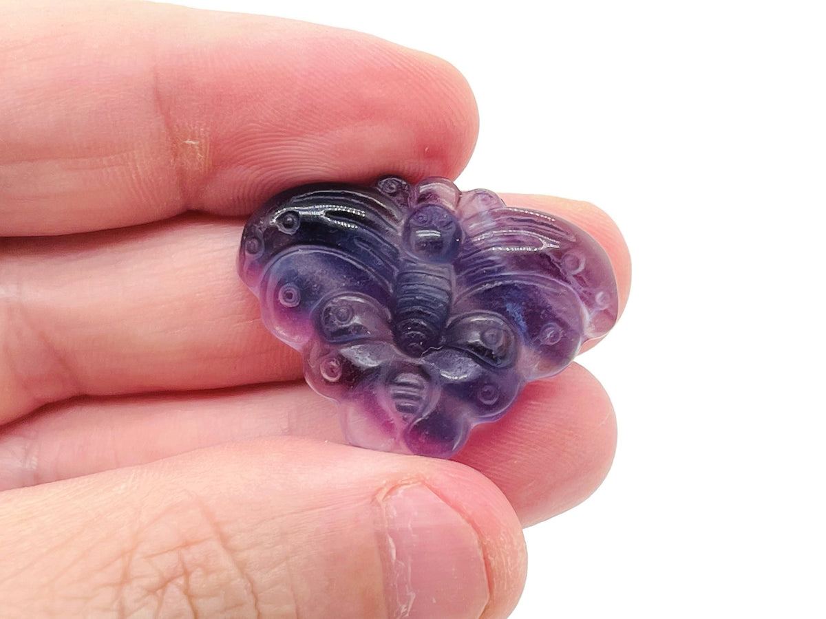 Fluorite butterfly carving gemstone by GemstoneGO, showing a colorful polished gemstone with intricate butterfly design.