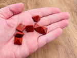 Red Jasper pyramid gemstone carving, 14mm, from GemstoneGO, showing a polished red stone pyramid with detailed faceted surfaces.