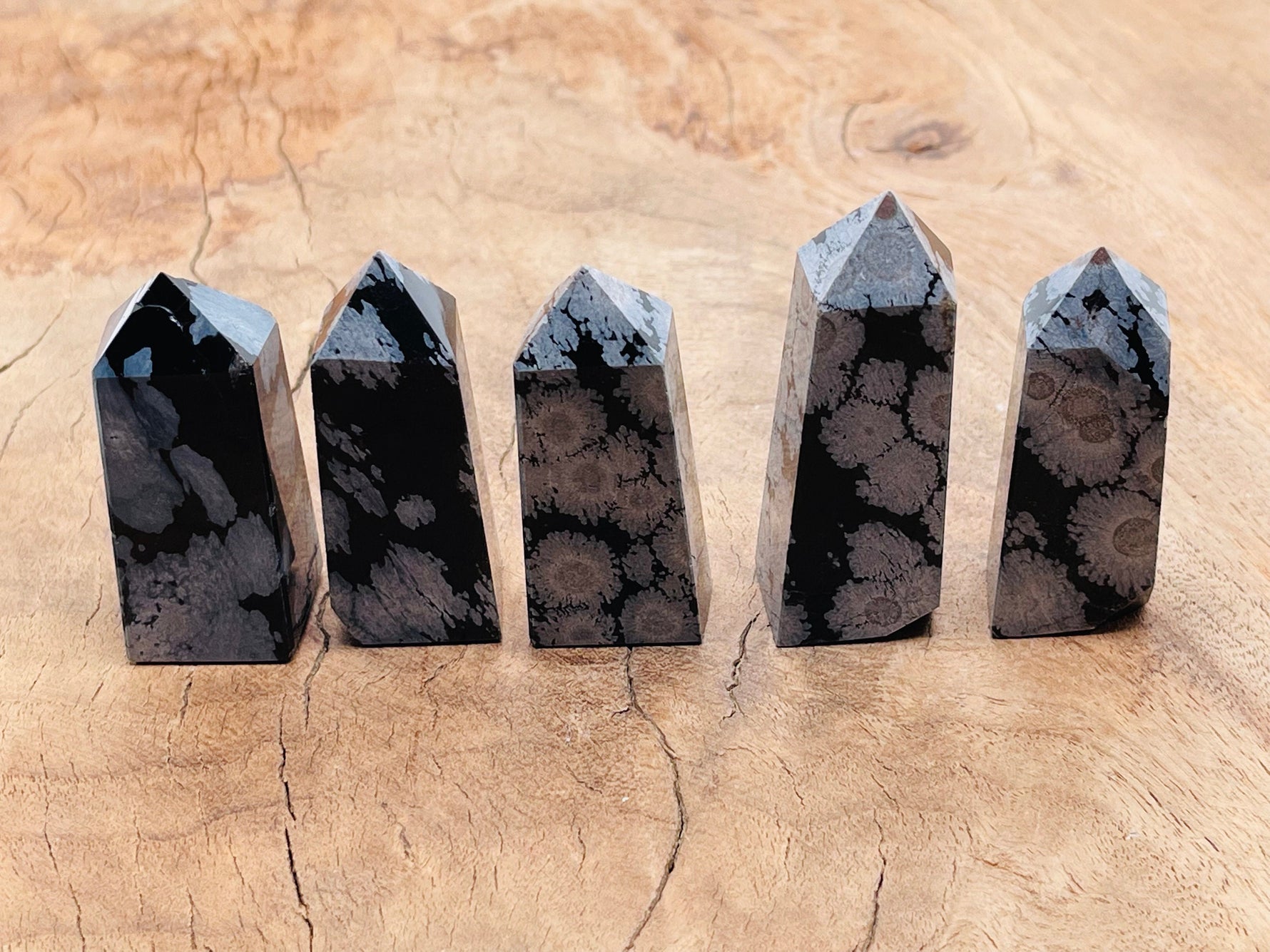 Snowflake Obsidian obelisk tower crystal from GemstoneGO, featuring black volcanic glass with white snowflake patterns and a polished finish.