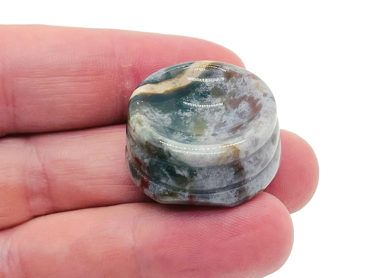 Moss agate crystal sphere on carved gemstone stand, decorative home decor piece showing green and brown mineral patterns.
