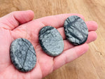 Black network jasper worry stone with smooth, polished surface, measuring 4.5x3.5cm, from GemstoneGO.