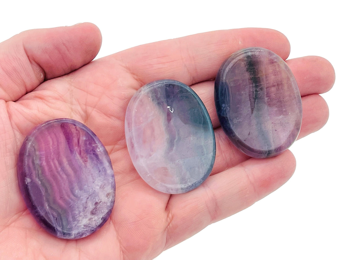 Smooth fluorite worry stone from GemstoneGO, measuring 4.5x3.5cm, featuring vibrant green and purple crystal patterns for calming use.