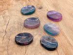 Polished fluorite worry stone from GemstoneGO, measuring 4.5x3.5cm, featuring vibrant green and purple crystal patterns.